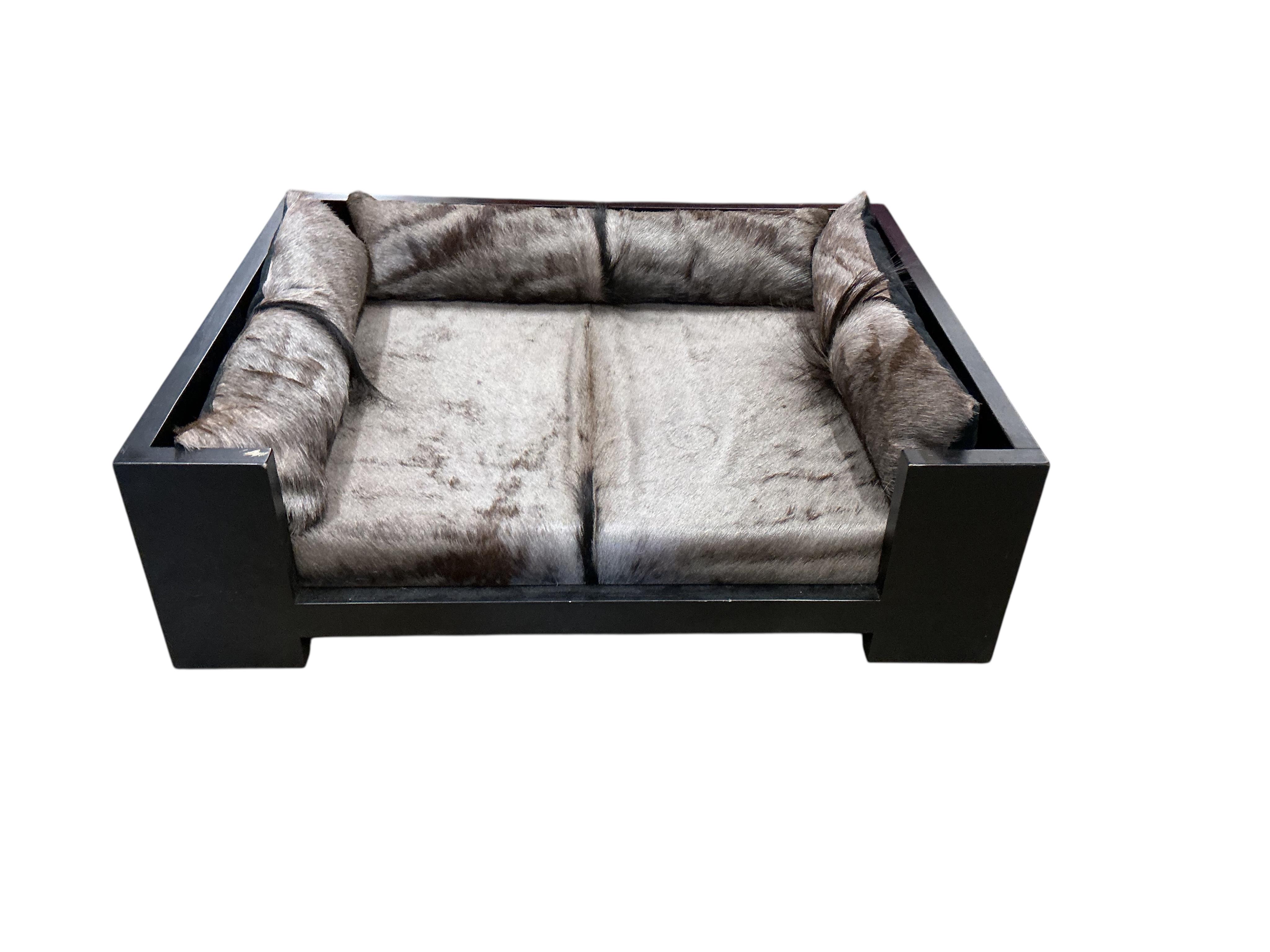 A contemporary ebonised dogs bed with faux fur cushions, width 97cm, depth 77cm, height 29cm